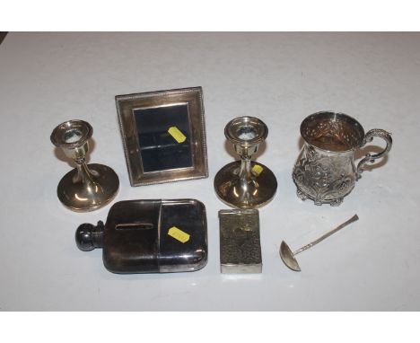 A pair of silver candlesticks with weighted bases; a silver photo frame; a silver spoon; a silver plated cup; a silver plated
