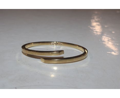 A yellow metal bangle marked 750, approx. 18gms 