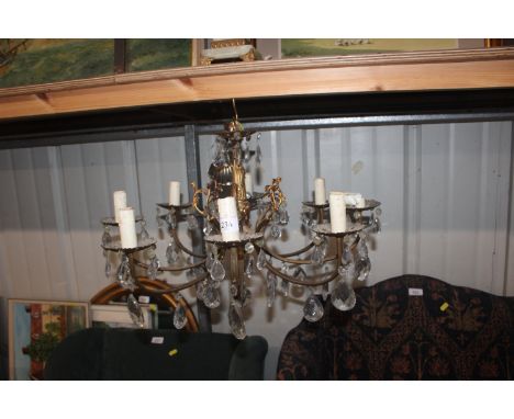 An eight branch chandelier with hanging glass drops; and an onyx and gilt metal table lamp and shade