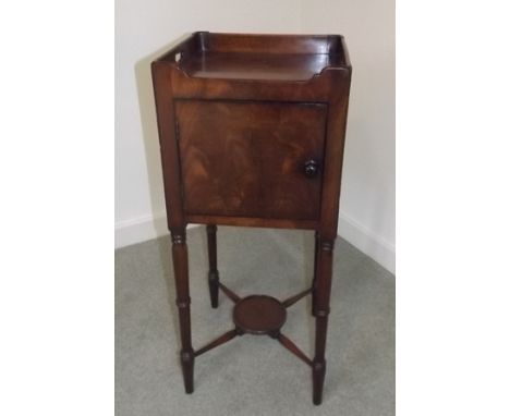 A GEORGIAN DESIGN MAHOGANY POT CUPBOARD having gallery top with pierced handles over single door on ring turned supports with