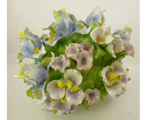 A LATE 20TH CENTURY CONTINENTAL CERAMIC CENTRE PIECE, modelled and painted as a basket of summer flowers, 35cm high 
