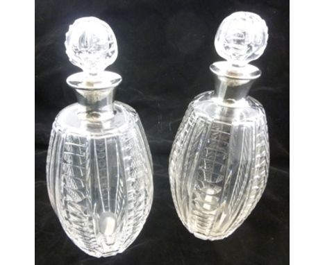 GOLDSMITHS & SILVERSMITHS CO. A PAIR OF SILVER MOUNTED CUT GLASS WINE DECANTERS each having blown glass stopper with facetted