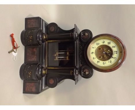 A VICTORIAN BLACK SLATE MANTEL CLOCK, inset with rouge marble panels and embossed cherub panels, column mounted, the circular