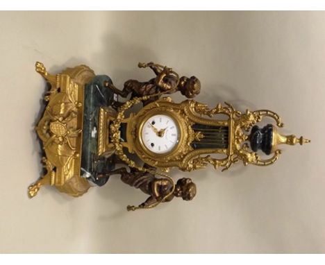 A 20TH CENTURY FRENCH EMPIRE DESIGN MANTEL CLOCK, of gilded ornate lyre form with urn mount, flanked by Satyrs bearing a flor