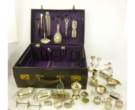 A TRAVELLING VANITY CASE containing a large selection of SILVER AND SILVER PLATED ITEMS including; a silver flask, a sauce bo