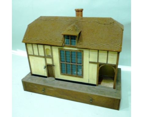 A c.1920's DOLLS HOUSE half timbered cottage design, with felt thatch design roof, front and side openings, fitted interior, 