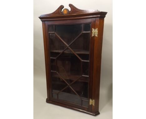 A 19TH CENTURY MAHOGANY HANGING CORNER CUPBOARD, with astragal glazed single door with fancy pierced brass hinges, 100cm high