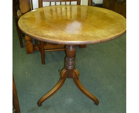 A 19TH CENTURY OAK SNAP-TOP WINE TABLE raised on ring turned stem with tripod base, 67cm diameter 