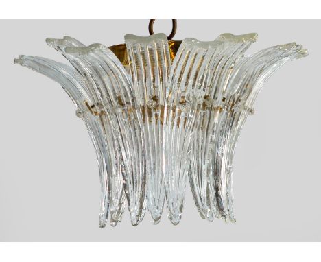 Messing und farbloses Glas. Korpus aus dicht gereihten und stark gebogten, reliefierten Zapfenmotiven. Innen zwei Lampenfassu