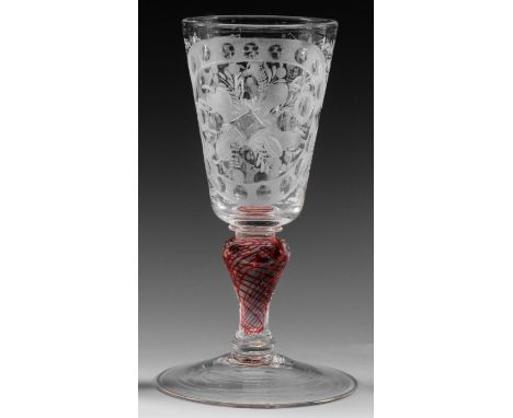 Farbloses Glas. Ansteigender Scheibenfuß, der Balusterschaft mit spiralig gedrehten, eingeschmolzenen Goldrubinfäden. Auf der
