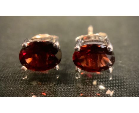 A pair of oval red garnet stud earrings, silver mounts, 1.9g gross. 