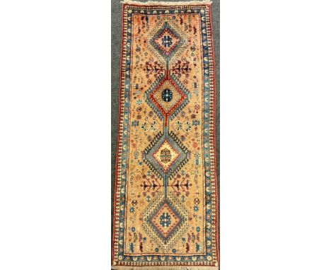 A North West Persian Yallemeh runner carpet, knotted with a row of four diamond-shaped medallions, within a field of stylised