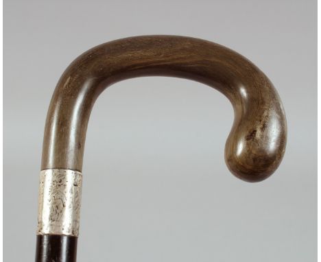 AN ANTIQUE RHINO HORN HANDLE WALKING STICK, with silver band, 90cm long.**Please note:&nbsp; this item can only be sold withi