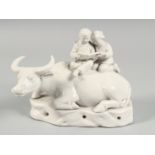 A CHINESE PORCELAIN FIGURE OF AN OXEN with two seated figures on his back, (af).