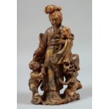 A CHINESE CARVED SOAPSTONE FIGURAL GROUP, beautifully carved to depict Guanyin holding a large