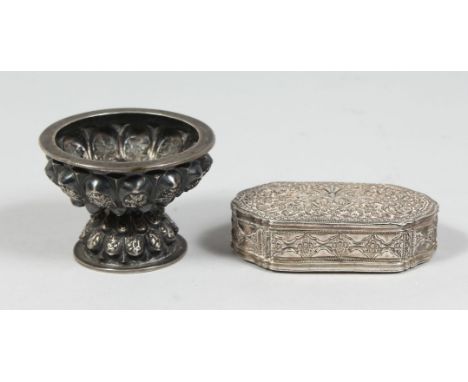 A SRI LANKAN SILVER BOX with hinged lid and embossed decoration, 9cm x 5.5cm, together with a Thai silver footed cup, 7.5cm d