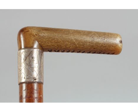 AN ANTIQUE RHINO HORN HANDLE WALKING STICK, with silver band, 86cm long.**Please note:&nbsp; this item can only be sold withi