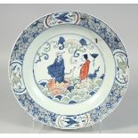 A CHINESE WUCAI PORCELAIN DISH, painted with figures and cranes, base with six-character mark,