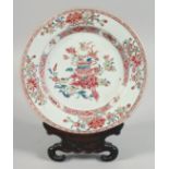 A CHINESE FAMILLE ROSE PORCELAIN PLATE with carved hardwood stand, plate 22.5cm diameter.