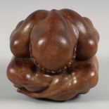A CHINESE HARDWOOD CARVING OF A HUNCHED FIGURE, his head in his hands with sorrow, 12cm high.
