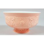 A CHINESE PINK GLAZED PORCELAIN BOWL, the exterior with raised decoration depicting dragons and