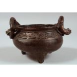 A CHINESE BRONZE TWIN HANDLE TRIPOD CENSER, the handles formed as coiling chilong, censer with a