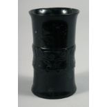 A CHINESE JADE HOLLOW CYLINDER, with a band of carved decoration, 11.5cm.