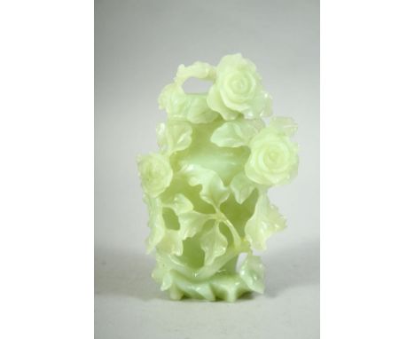 A CHINESE CARVED JADE VASE AND COVER, carved in relief with flowers and vine, 16cm high.