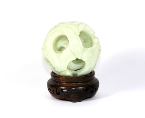 A Chinese carved jade/hardstone concentric ball on wooden stand, Diam: 9cm