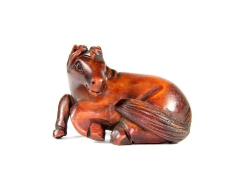A signed carved fruitwood netsuke of a horse with black onyx eyes