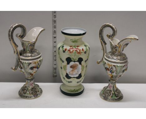 A hand painted glass vase and two ceramic ewers. Slight chip to rim of vase 