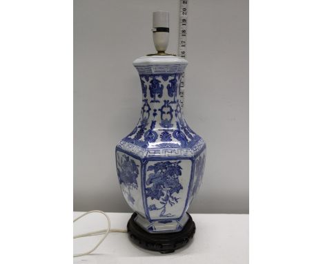 A Chinese blue and white ceramic lamp base on stand. Postage unavailable 