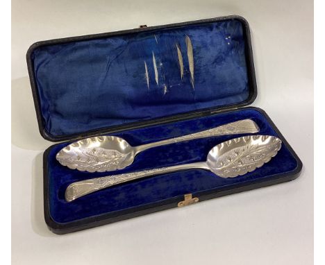 EXETER: A good boxed pair of silver berry spoons with chased decoration. By SH. Approx. 70 grams. Est. £60 - £80.