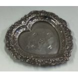 A heart-shaped silver dish with chased border.