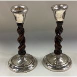 CHESTER: A pair of silver mounted and wood candlesticks.
