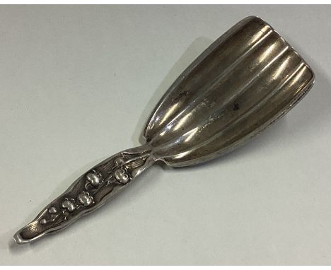 An American Sterling silver caddy spoon chased with floral decoration. Approx. 14 grams. Est. £20 - £30.