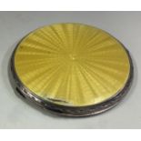 A silver and yellow enamelled compact.