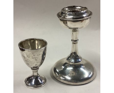 A plain Edwardian silver candlestick together with a small trophy cup. Various dates and makers. Approx. 185 grams of gross w