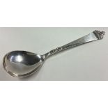 A stylish silver spoon with scroll decoration.