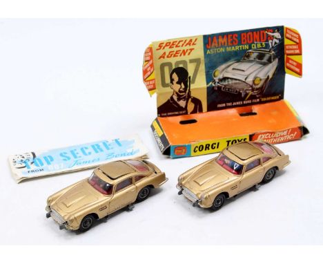 2 Corgi Toys No. 261 James Bond's Aston Martin DB5, both with a gold body, red interior, and wire wheels, one model has the b