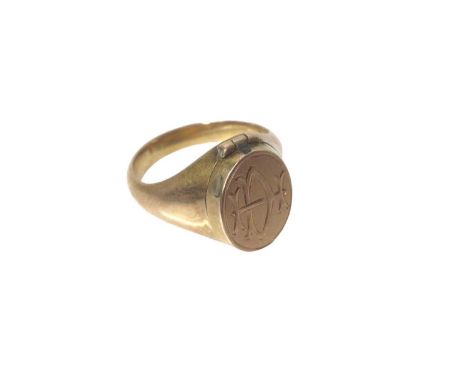 Victorian yellow metal signet ring with engraved initials and hinged locket compartment containing a ceramic portrait panel. 