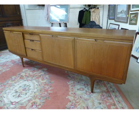 Large Mid Century Teak side board with pull down door, cupboards and drawers on stick legs