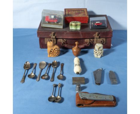 A small vintage suitcase containing spoons, penknives and other collectable items