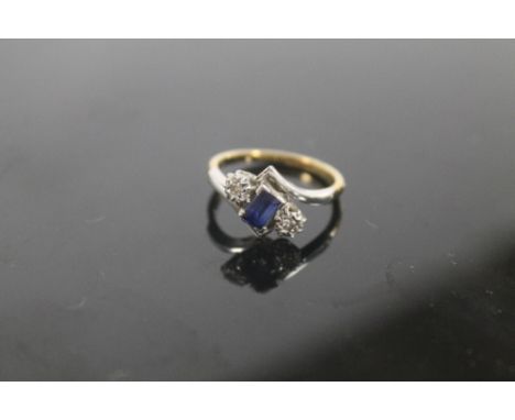 A 9ct GOLD AND PLATINUM DIAMOND AND SAPPHIRE CROSS OVER RING  