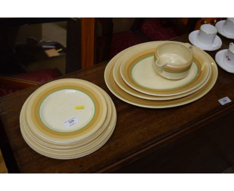 A quantity of Clarice Cliff dinner, side and meat plates; and a sauce boat