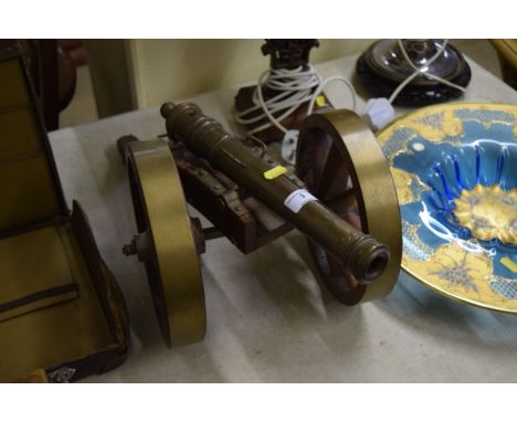 A large brass and wooden model cannon 