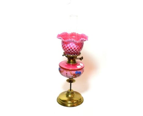^ A late Victorian brass oil lamp, with pink floral glass reservoir and pink glass shade, height excluding chimney 47cm 