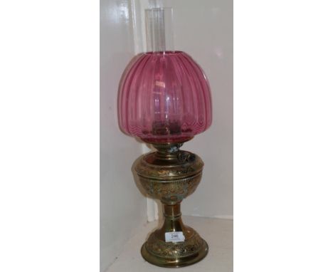 A Victorian oil lamp, with a cranberry glass shade 