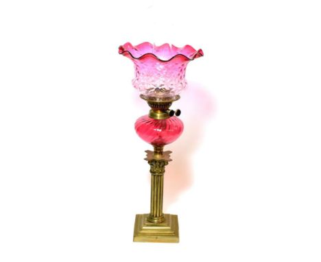 ^ A Victorian brass oil lamp with cranberry glass reservoir, height excluding chimney 56cm 