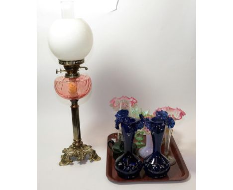 A quantity of coloured glassware including vases and an oil lamp with pink glass reservoir
